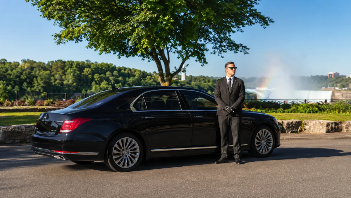 Glossy black luxury sedan with a uniformed chauffeur — Niagara Falls tour from Toronto